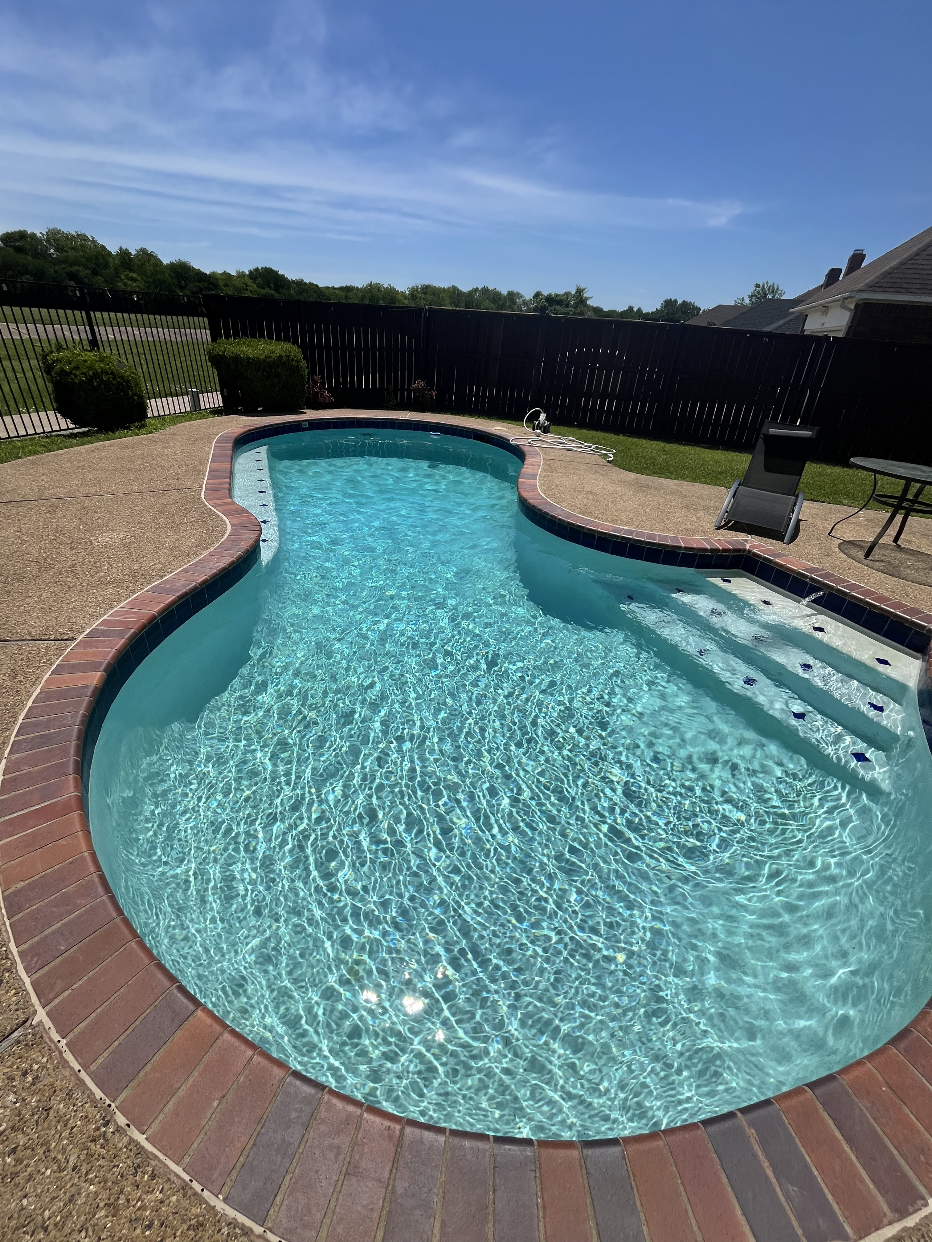 Clean kidney-shaped residential pool in Grapevine TX maintained with weekly skimming, vacuuming, and water testing