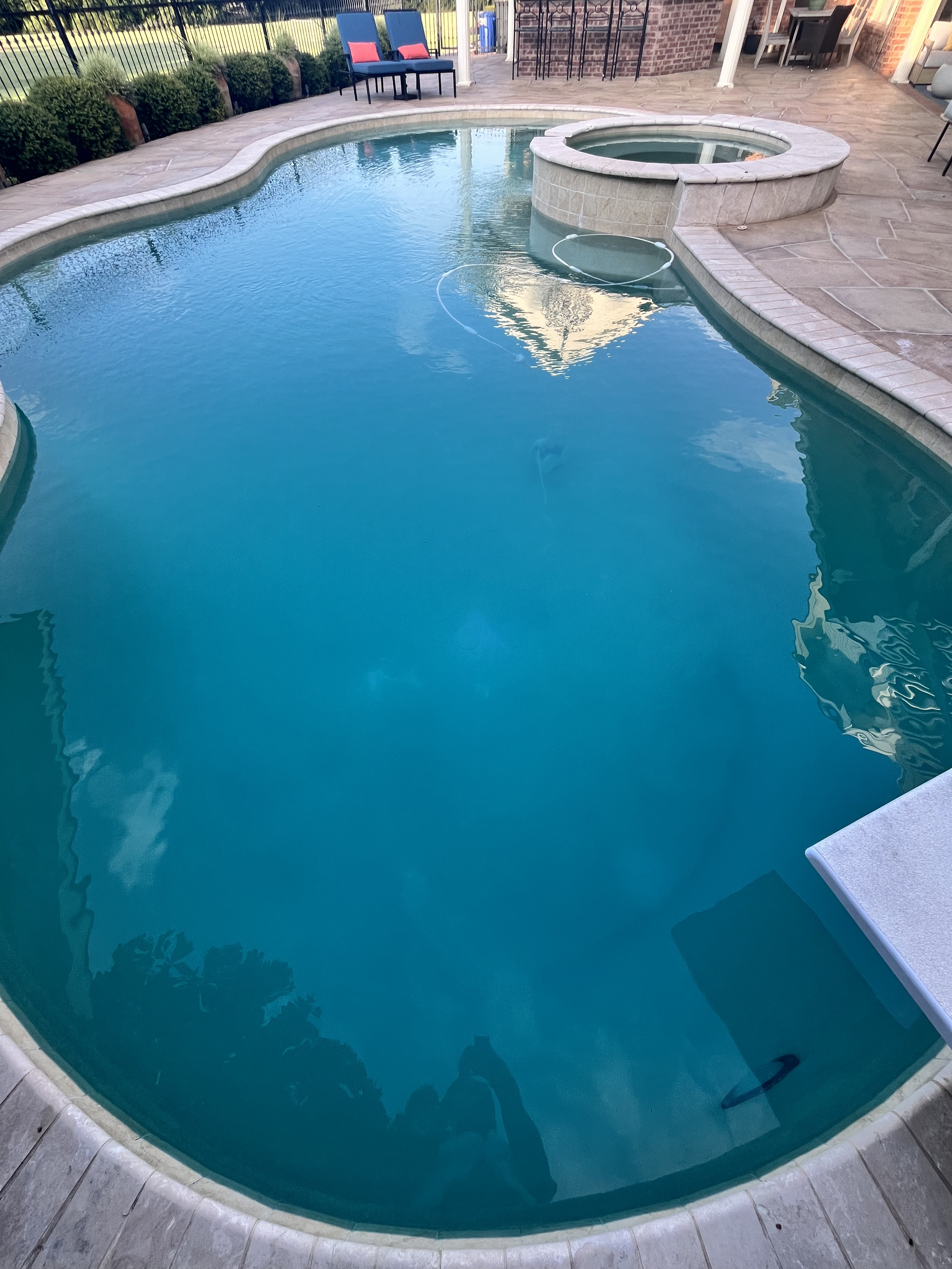 Luxury freeform pool with raised stone spa in University Park TX kept pristine with detail-focused weekly pool cleaning