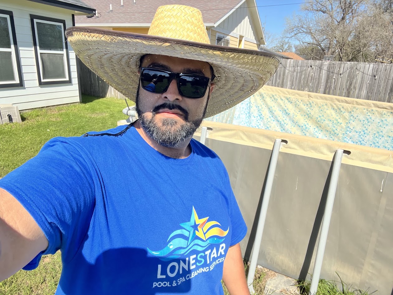 Lonestar Pool and Spa Cleaning owner in branded shirt beside a backyard pool in Arlington TX